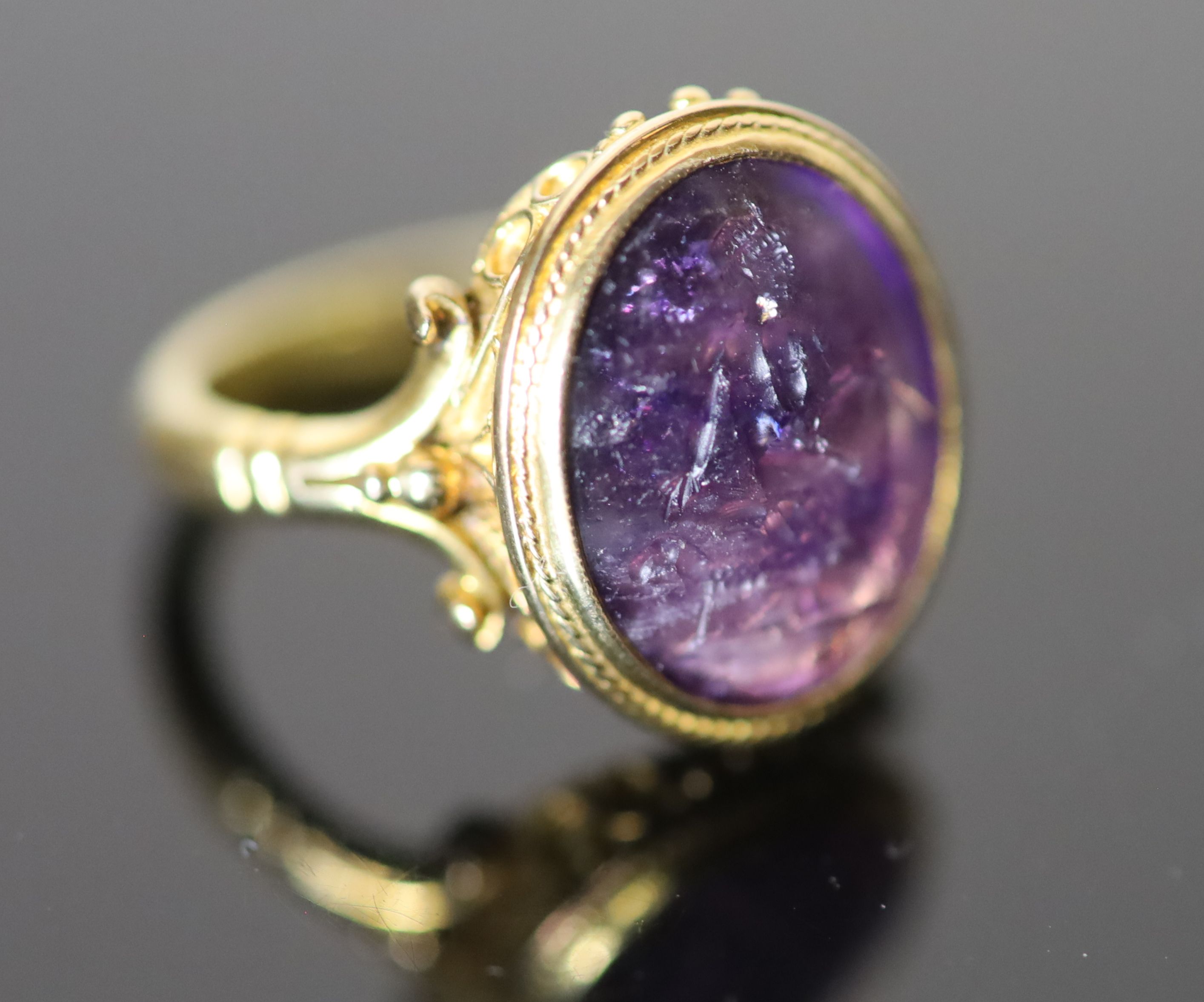 A 19th century style gold ring set with an antique intaglio oval amethyst,